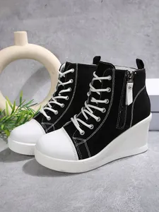 Detailed side view of stylish black and white high-top wedge canvas sneakers for women