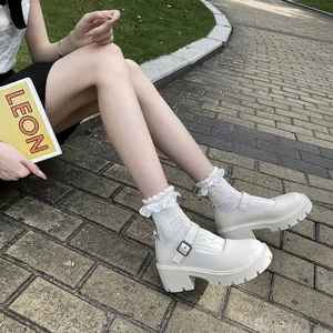 Outdoor shot of white platform Mary Jane shoes with chunky heels and lace socks