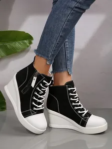 Detailed close-up of black and white high-top canvas wedge sneakers with side zipper