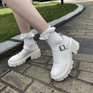 Side view of white platform Mary Jane shoes with ruffled white socks on stone path