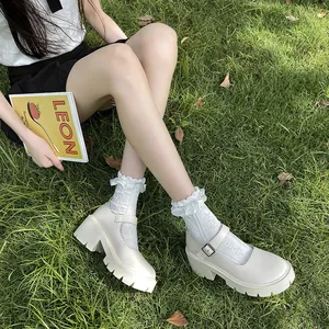 Elegant white platform Mary Jane shoes styled with ruffle socks on a green lawn background