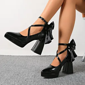 Zwarte lakschoenen met hoge hak, puntige neus, kruisbandjes en zijden strikken achterop