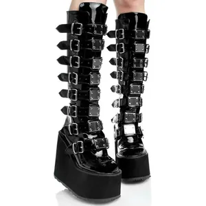 Close-up of black punk knee-high boots with multiple metal buckles and 11cm wedge platform