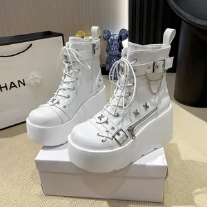 Seitenansicht weißer Plateau-Stiefel mit Metallketten und Schnallenverzierungen
