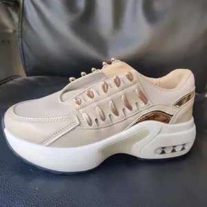 Primer plano de zapatillas beige con plataforma, detalles metálicos y malla transpirable