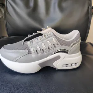 Perfil lateral de zapatillas de plataforma de malla gris con suela de cuña blanca y cordones
