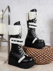 Vue détaillée de bottes de neige à plateforme noires avec bordure en fourrure blanche