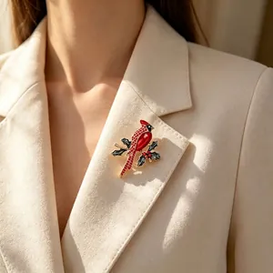 Elegant red cardinal bird brooch with holly berries pinned on a cream blazer lapel