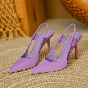 Side detail of elegant purple satin pointed-toe slingback high-heel pumps on a woven mat