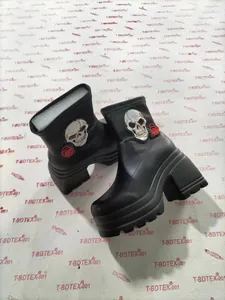 Detailed view of women's black platform ankle boots with gothic skull and rose embroidery detail.