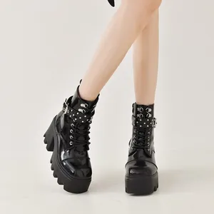 Gros plan de bottines à plateforme en cuir verni noir avec clous et boucles élégantes