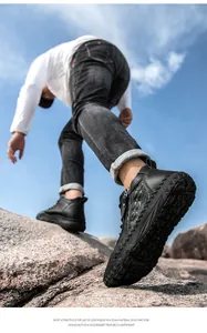 Low-angle detailed shot of men's black leather Martin boots on rocky outdoor terrain
