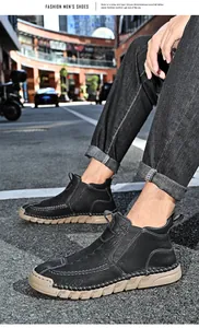 Detailed view of black leather mid-top Martin boots for men in a street setting.