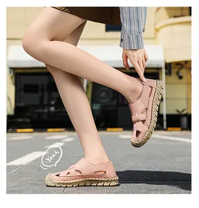 Lifestyle-Außenansicht von rosa atmungsaktiven handgenähten Sandalen für Damen.
