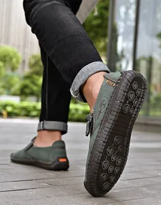 Vista detallada de mocasines verdes para hombre con cremallera lateral y decorativa