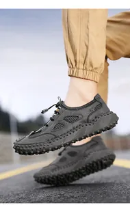 Dettaglio scarpe da trekking in rete grigia con suole in gomma antiscivolo chiodate