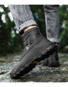 Detailansicht schwarzer halbhoher Herren-Winterstiefel auf einem steinernen Außenweg