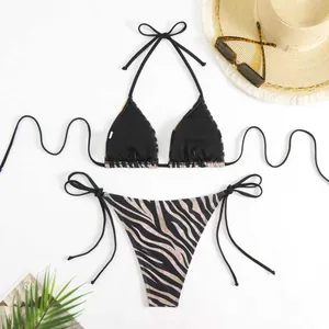 Vue détaillée d'un ensemble bikini zébré avec un chapeau de paille et des lunettes.