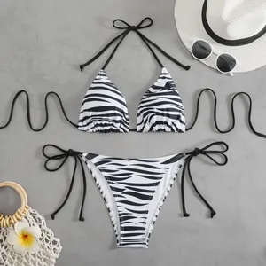 Ensemble bikini à imprimé zèbre avec chapeau et lunettes sur un fond gris texturé