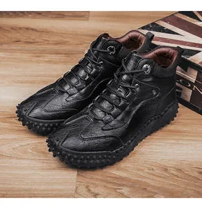 Detail view of rugged black leather outdoor hiking boots with studded anti-slip soles.
