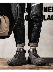Close-up of men's high-top outdoor casual shoes with rugged studded rubber soles.