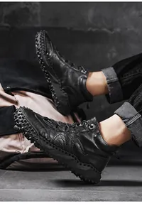 Detailed side view of black high-top outdoor boots with studded non-slip soles
