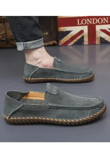 Détail de mocassins en daim gris pour hommes avec couture main, chaussures de conduite