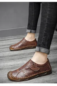 Dettaglio di mocassini casual in pelle marrone fatti a mano con cuciture e cinturino.
