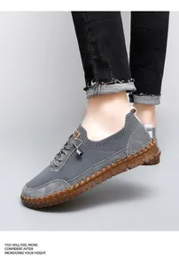 Side view detail of grey mesh casual men's shoes with brown hand-stitched sole