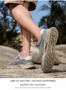 Primer plano de zapatos de trekking de malla gris transpirable en terreno rocoso