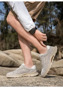 Zapatos de agua transpirables para hombre presentados en entorno natural rocoso.