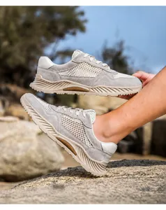 Detalle de zapatos de río de malla gris transpirable para hombre en un paisaje rocoso.