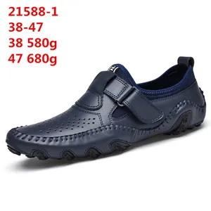 Navy blue perforated leather loafers for men with adjustable strap and pebble sole.