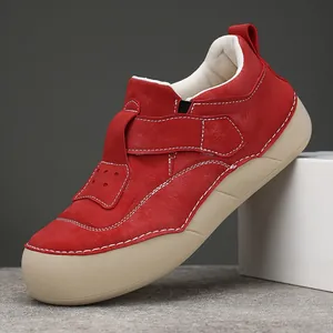 Scarpe casual rosse da donna con suola spessa e cuciture bianche su sfondo grigio.