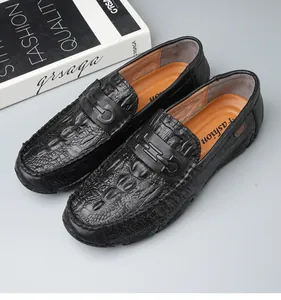 Macro view of black crocodile pattern leather loafers featuring stylish metal buckle detail
