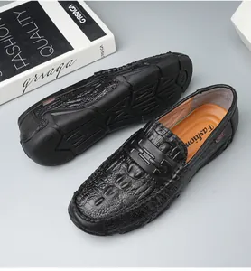 Detail view of black crocodile pattern leather loafers with durable rubber driver sole
