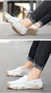 White leather loafers with crocodile texture for men shown in a casual outdoor setting