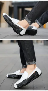 Detailed side view of men's black and white crocodile textured leather loafers.