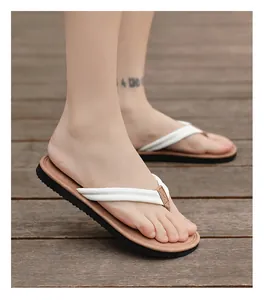 Nahaufnahme von stilvollen Herren-Flip-Flops mit weißen Riemen auf einem Holzdeck