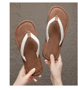 Detailaufnahme von bequemen braunen Flip-Flops mit weißen gewebten Riemen für Herren
