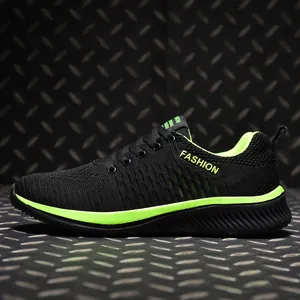 Side view of black and neon green breathable flyknit low-top sneakers on industrial background