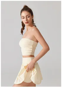 Zijaanzicht van een crème geplooide sport-tube top en een bijpassende korte sportrok