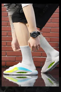 Close-up of white sporty men's slide sandals with colorful side details on wet ground