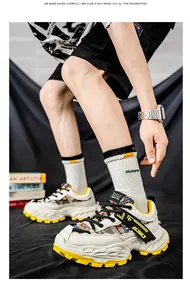 Λεπτομερής προβολή ανδρικών chunky sneakers με κίτρινες λεπτομέρειες και χοντρές σόλες.