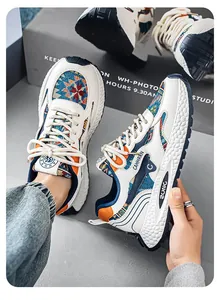 Nahaufnahme weißer Chunky-Sneaker mit bunten Ethno-Stoffmustern und orangefarbenen Akzenten