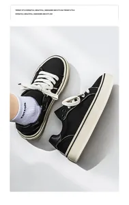 Close-up top view of premium black canvas board shoes with thick white soles and wide laces