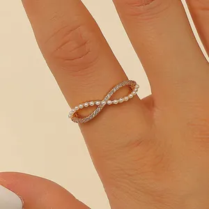 Close-up detail of elegant gold-toned infinity ring featuring pearls and sparkling crystals