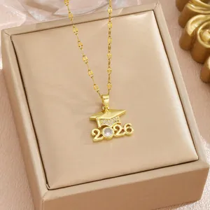 Close-up detail of golden graduation necklace with 2026 doctoral cap pendant with stones