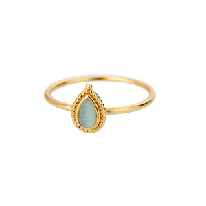 Close-up detail of a vintage gold-plated stainless steel ring with pear blue stone