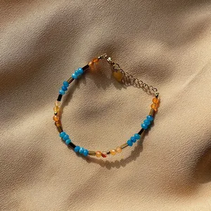 Detailed view of colorful faceted natural stones and gold beads on a silk background